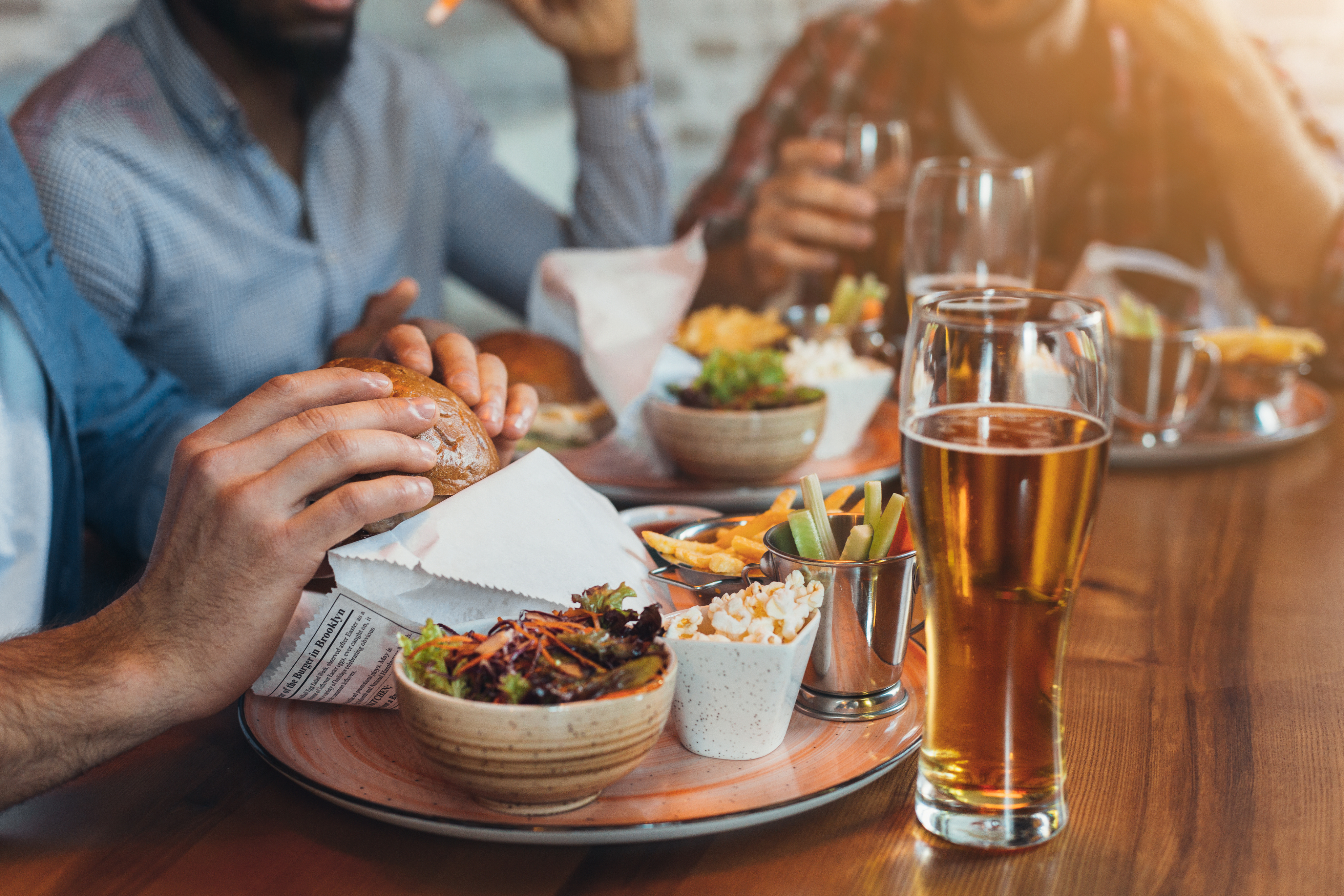 On the home page, you'll find people gathered around a table enjoying burgers, salad, fries, and beers.